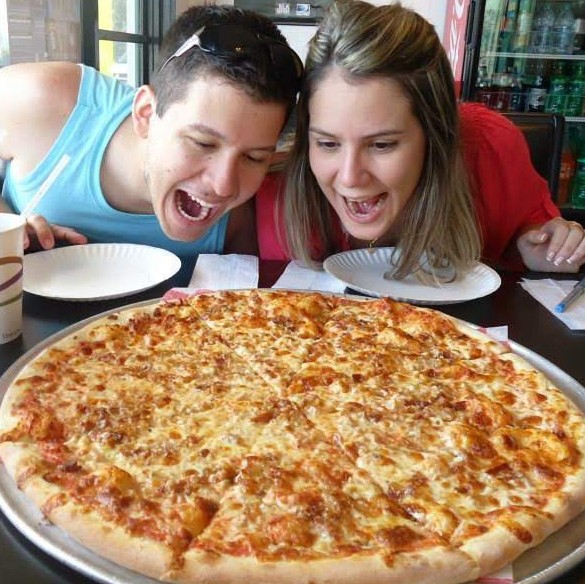 casal comendo pizza enorme